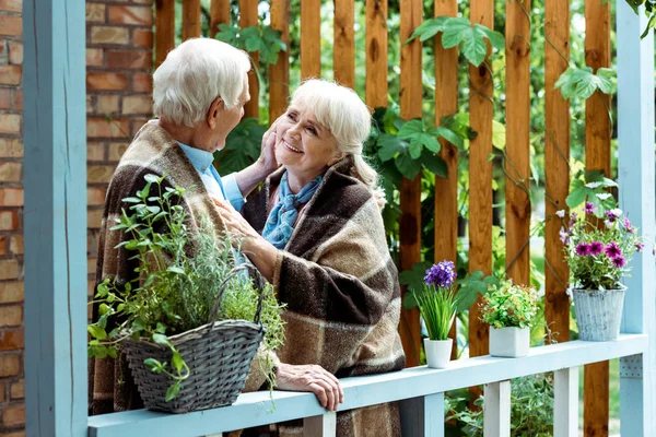 Foyer sélectif de l'homme âgé touchant le visage de la femme heureuse avec les cheveux gris — Photo de stock