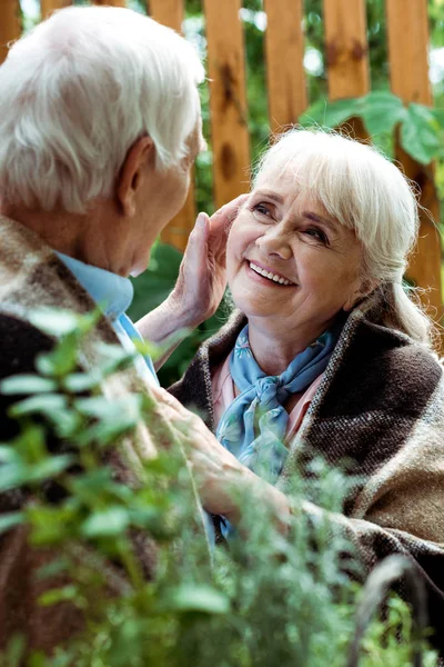 Enfoque selectivo de la mujer feliz con el pelo gris mirando al marido jubilado - foto de stock