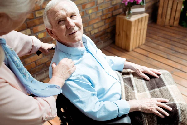 Enfoque selectivo del hombre discapacitado senior mirando a la esposa - foto de stock