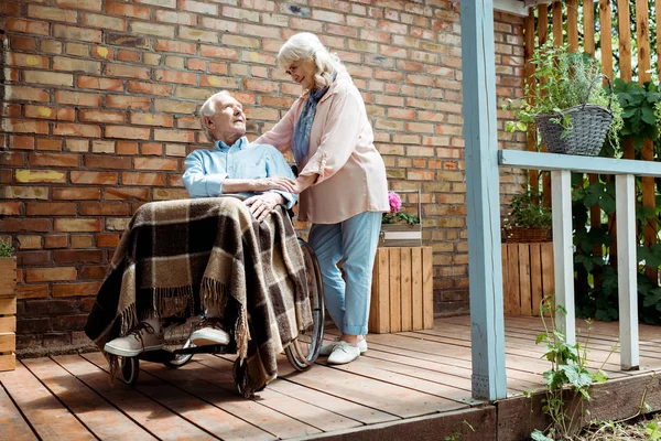Niedrigwinkel-Ansicht eines älteren behinderten Mannes, der im Rollstuhl neben seiner Frau sitzt — Stockfoto