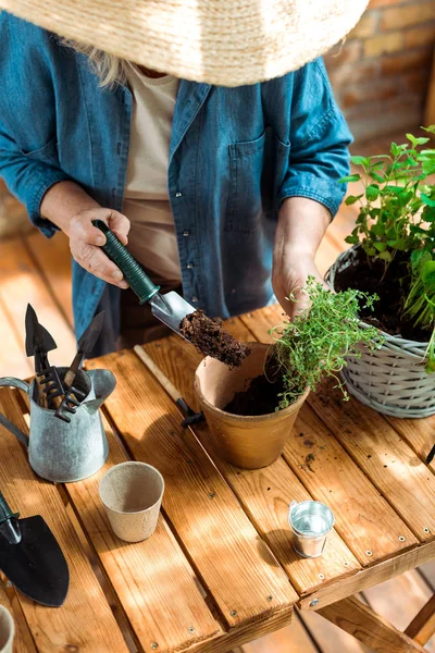 Blick auf Seniorin mit Schaufel und Boden in der Nähe von Blumentopf — Stockfoto