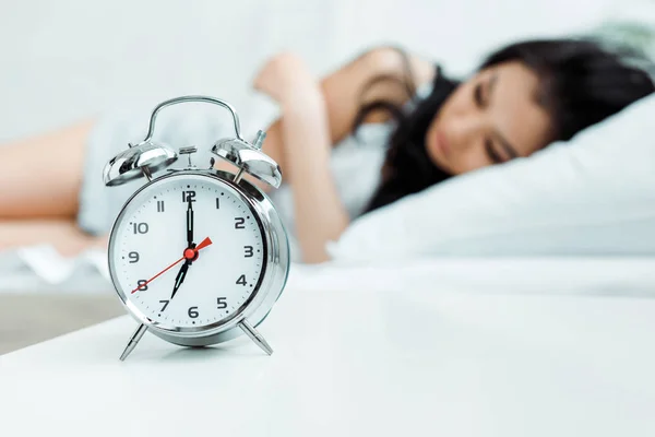 Selective focus of retro alarm clock near sleeping girl — Stock Photo