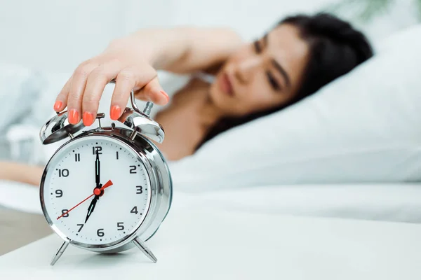 Selective focus of retro alarm clock near asian woman — Stock Photo