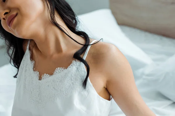 Abgeschnittene Ansicht der fröhlichen jungen brünetten Frau im Schlafzimmer — Stockfoto