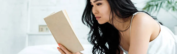 Panoramique de brunette thai femme lecture livre à la maison — Photo de stock