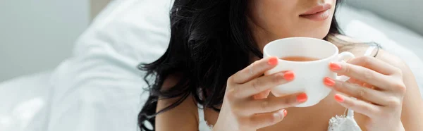 Plano panorámico de mujer morena sosteniendo taza con bebida - foto de stock