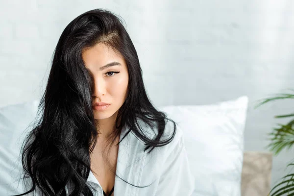 Attractive brunette thai woman looking at camera in bedroom — Stock Photo