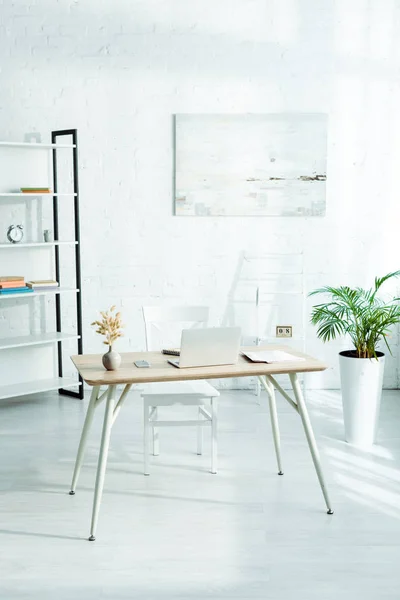 Laptop and smartphone on wooden table in modern office — Stock Photo