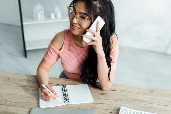 Alegre asiático mulher no óculos falando no smartphone no escritório — Fotografia de Stock