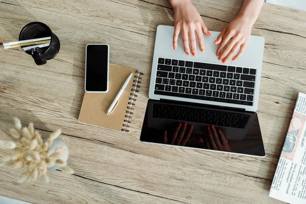 Cropped view of young woman using laptop with blank screen — Stock Photo