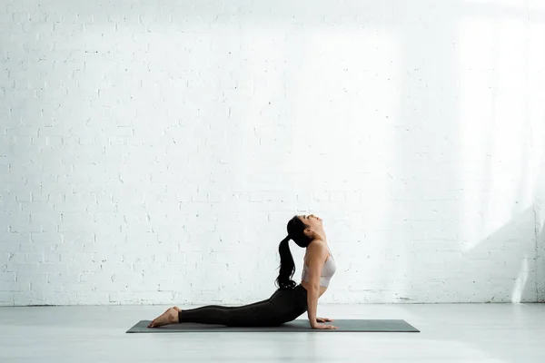 Jolie femme thai faire de l'exercice sur tapis de yoga — Photo de stock