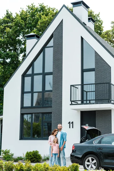 Homme gai debout avec femme attrayante et mignon enfant — Photo de stock