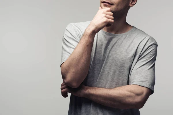 Visión parcial del hombre reflexivo agarrado de la mano cerca de la cara aislado en gris, emoción humana y concepto de expresión - foto de stock