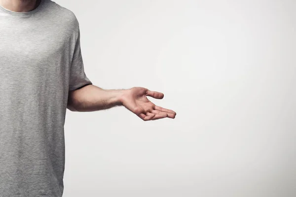 Cropped view of man showing shrug gesture isolated on grey, human emotion and expression concept — Stock Photo