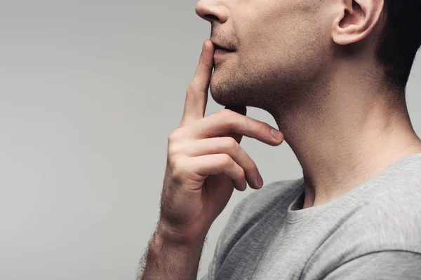 Visión parcial del hombre mudo mostrando signo de silencio aislado en gris, emoción humana y concepto de expresión - foto de stock