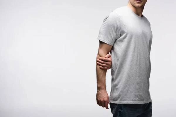 Cropped view of man holding hand behind back isolated on grey, human emotion and expression concept — Stock Photo