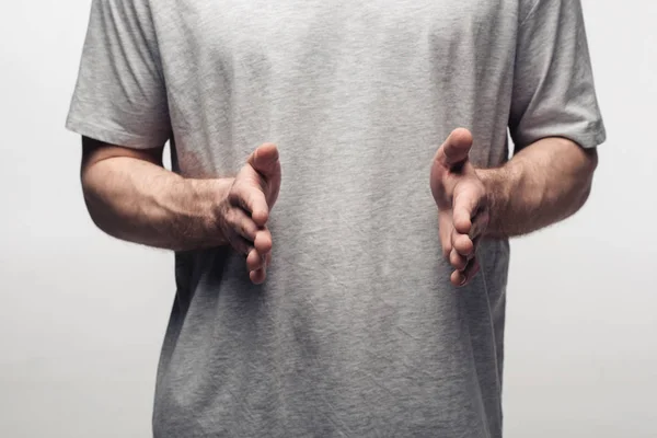 Visión parcial del hombre mostrando un gesto de tamaño aislado en gris, emoción humana y concepto de expresión - foto de stock