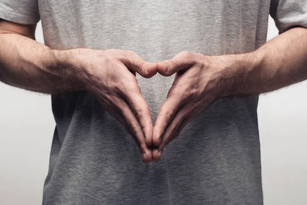 Visión parcial del hombre mostrando gesto de campanario mientras utiliza el lenguaje corporal aislado en gris, emoción humana y concepto de expresión - foto de stock