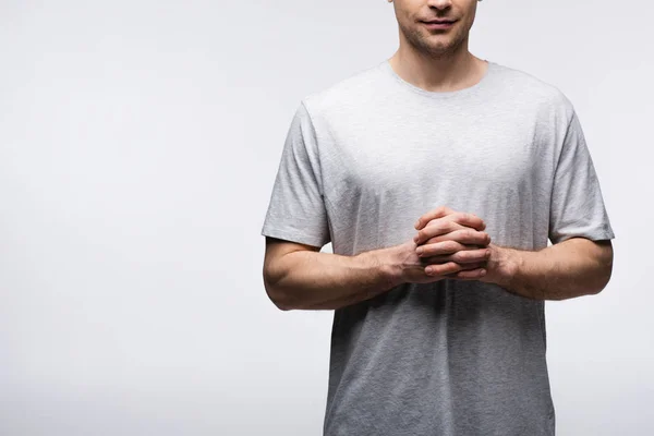 Visão parcial do homem de pé com as mãos apertadas isoladas em cinza, emoção humana e conceito de expressão — Stock Photo