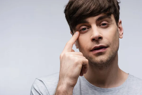 Ciego señalando con el dedo a los ojos aislado en gris, emoción humana y concepto de expresión - foto de stock