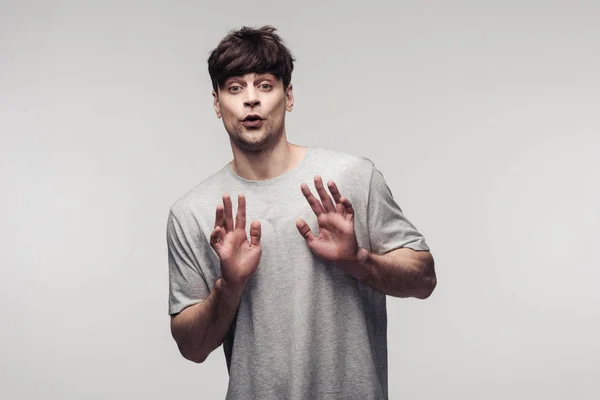 Scared man showing stop gesture isolated on grey, human emotion and expression concept — Stock Photo