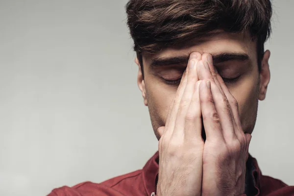 Upset man with closed eyes covering face with hands isolated on grey, human emotion and expression concept — Stock Photo