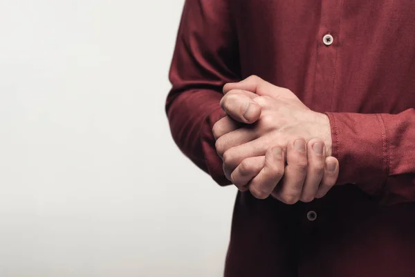 Partial view of man with clenched hands using body language isolated on grey, human emotion and expression concept — Stock Photo