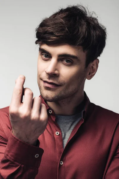 Hombre guapo mostrando gesto de dinero y mirando a la cámara aislado en gris, emoción humana y concepto de expresión - foto de stock