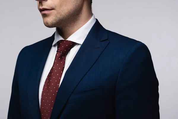Vista parcial de empresario confiado en traje y corbata aislado en gris - foto de stock
