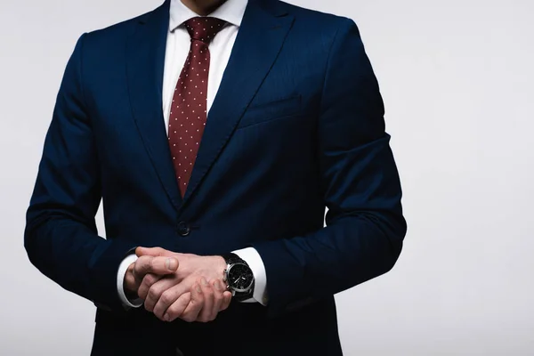 Частичный взгляд уверенного бизнесмена с сжатыми руками, изолированными на серой, человеческой эмоций и выражений концепции — стоковое фото