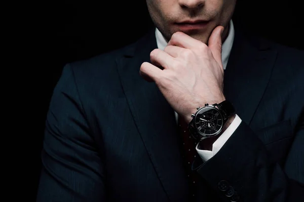 Обрізаний вид вдумливого бізнесмена, тримає руку біля обличчя ізольовано на чорному — стокове фото