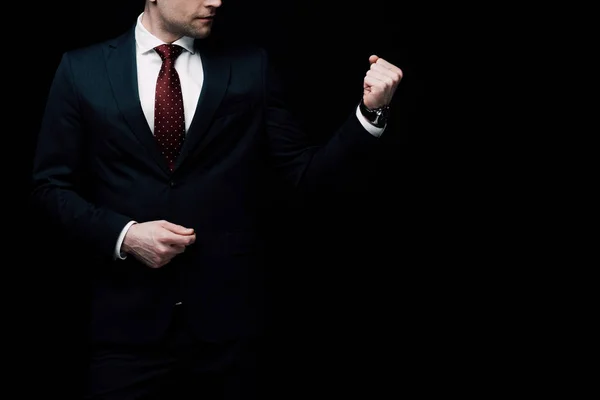 Ausgeschnittene Ansicht eines wütenden Geschäftsmannes, der die Faust isoliert auf schwarzem, menschlichem Emotions- und Ausdruckskonzept zeigt — Stockfoto