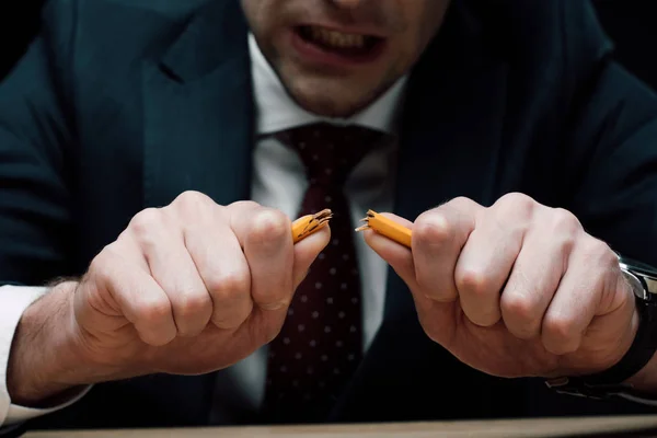 Abgeschnittene Ansicht wütender Geschäftsmann bremst Bleistift isoliert auf schwarz — Stockfoto