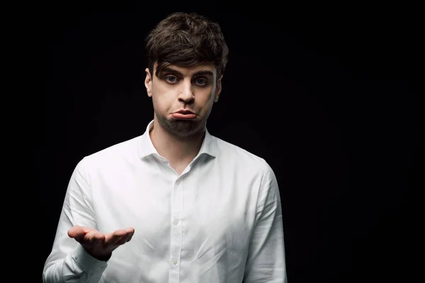 Upset, drunk businessman gesturing with hand and grimacing isolated on black — Stock Photo