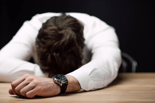 Betrunkener, erschöpfter Geschäftsmann liegt auf Holztisch isoliert auf Schwarz — Stockfoto