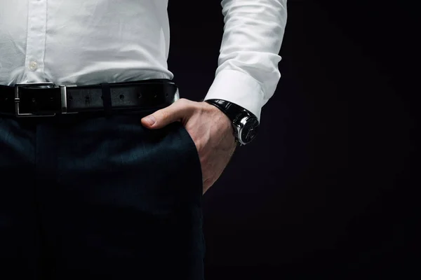 Частковий погляд бізнесмен тримає руку в кишені ізольовані на чорному — стокове фото