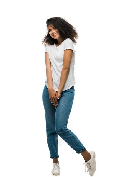 Heureuse fille afro-américaine en t-shirt blanc debout isolé sur blanc — Photo de stock