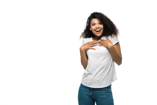 Chica afroamericana feliz en camiseta blanca de pie en vaqueros azules aislados en blanco - foto de stock