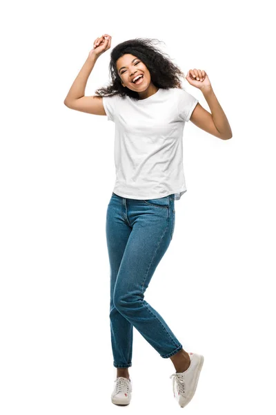 Happy african american girl in blue jeans celebrating triumph isolated on white — Stock Photo
