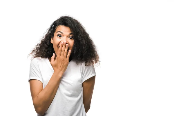 Encaracolado afro-americano mulher cobrindo rosto com a mão e olhando para a câmera isolada no branco — Fotografia de Stock