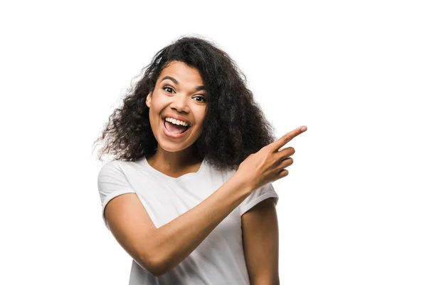 Happy curly african american woman pointing with finger isolated on white — Stock Photo