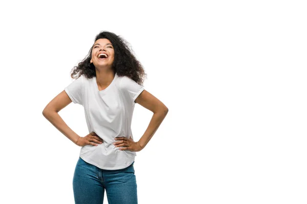 Felice donna afroamericana ridere e in piedi con le mani sui fianchi isolati su bianco — Foto stock