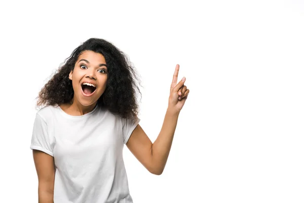 Mujer afroamericana positiva en camiseta blanca señalando con el dedo aislado en blanco - foto de stock