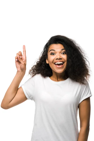 Sonriente mujer afroamericana en camiseta blanca señalando con el dedo aislado en blanco - foto de stock