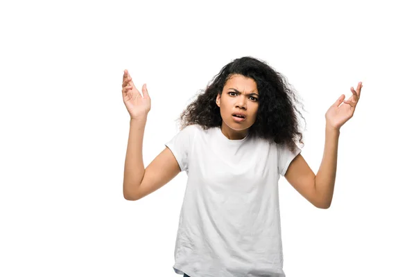 Upset curly african american girl in white t-shirt gesturing isolated on white — Stock Photo