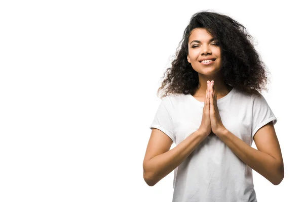 Heureuse femme afro-américaine avec les mains priantes et les yeux fermés isolés sur blanc — Photo de stock
