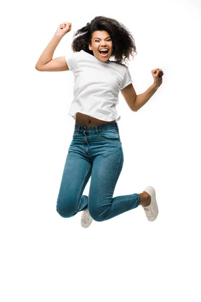Mujer afroamericana feliz gesto mientras se celebra y salta aislado en blanco - foto de stock