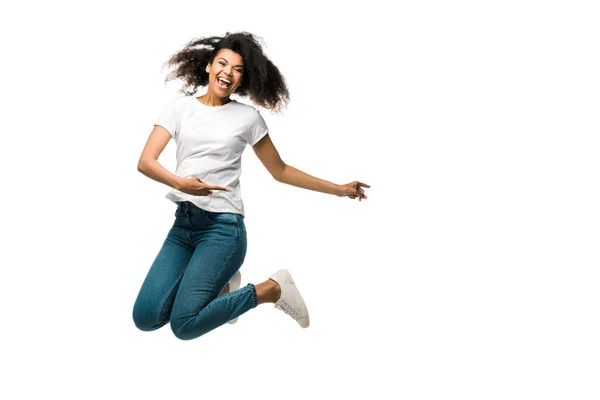 Positif afro-américaine femme pointant avec les doigts et sautant isolé sur blanc — Photo de stock