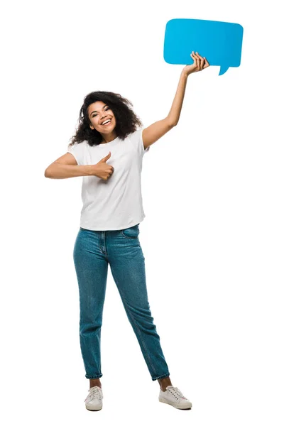 Felice ragazza afro-americana tenendo la bolla discorso blu e mostrando pollice in alto isolato su bianco — Foto stock