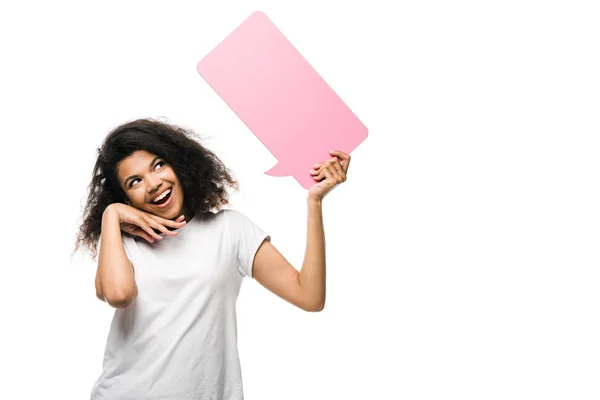 Щаслива афроамериканська дівчина дивиться на рожеву бульбашку мовлення і торкається обличчя ізольовано на білому — стокове фото